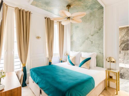 une chambre d'hôtel avec un lit avec une couverture bleue dans l'établissement Merveil - Luxury Suite - Champs Elysees - Mauroy I, à Paris
