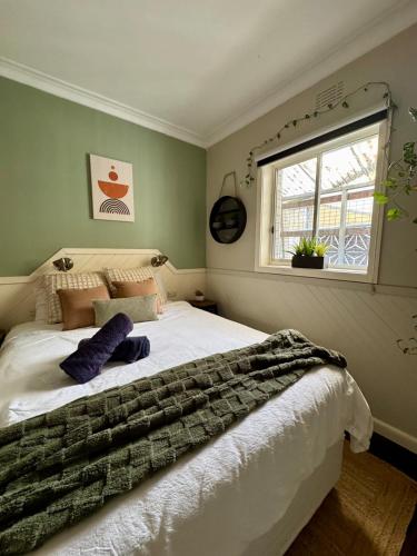 a bedroom with a large white bed with a window at Indys Place in Bright