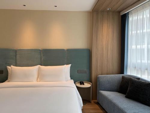 a bedroom with a bed and a couch at Laya Suites and Residences in Bang Tao Beach