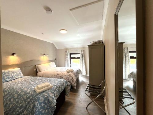 a bedroom with two beds and a mirror at Tigh Fitz Apartments - Inis Mór, Aran Island in Inis Mor