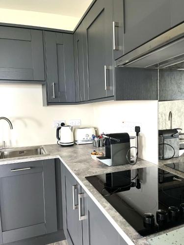 a kitchen with black cabinets and a counter top at Tigh Fitz Apartments - Inis Mór, Aran Island in Inis Mor