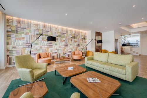 a living room with couches and tables and a large mural at Hotel Marina Rio in Lagos