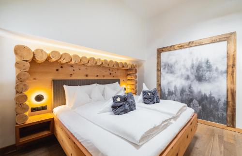 a bedroom with a bed made out of logs at Montresor Hotel Pfeldererhof in Pfelders
