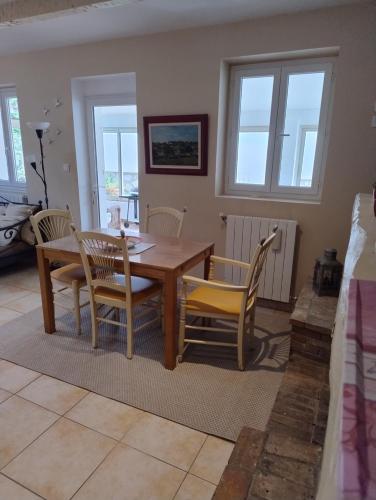 une salle à manger avec une table et des chaises en bois dans l'établissement la plage en face , 2 chambres clim parking, au Pradet