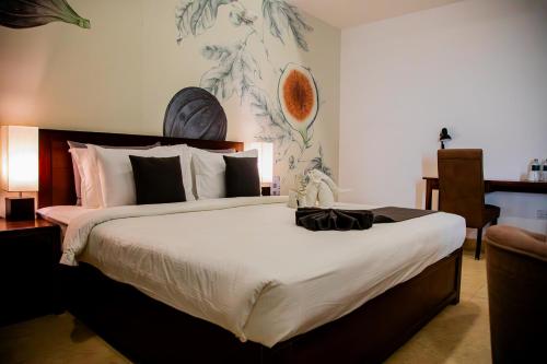 a bedroom with a large bed and a desk at Morven Hotel Colombo in Colombo