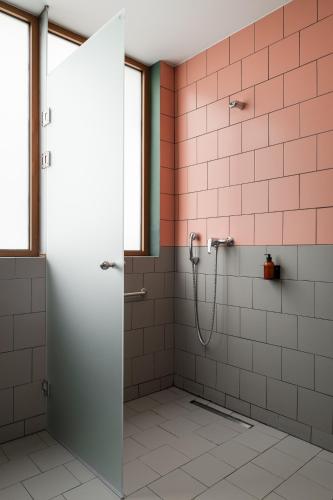 a bathroom with a shower with pink tiles at Zeus is Loose Hostel in Thessaloniki