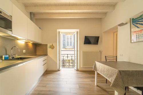 a kitchen with a sink and a table in a room at Lovely apartment in the walled city with WiFi e AC in Como