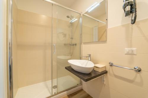 a bathroom with a sink and a glass shower at Lovely apartment in the walled city with WiFi e AC in Como