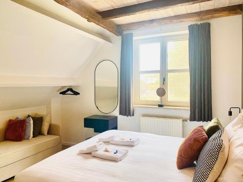 a bedroom with a bed with two towels on it at Landgoed De Hoogmolen in Oudsbergen 