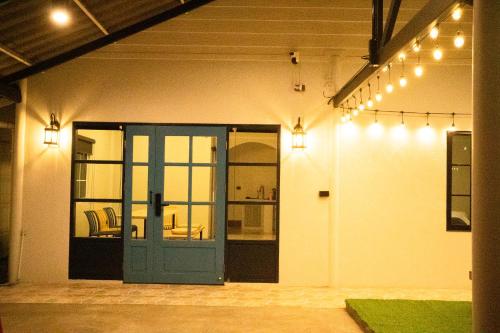 an open garage with a blue door and lights at Runway Tail 145 in Sathani Lat Krabang