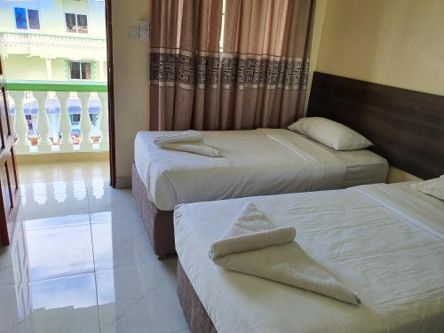 a hotel room with two beds and a window at Prestige Leisure Hotel in Mtwapa