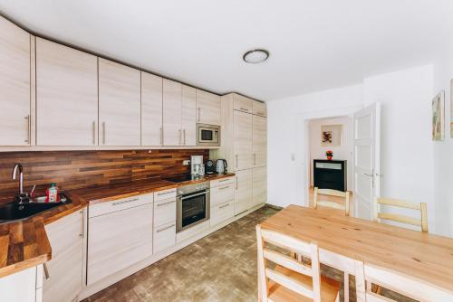 a kitchen with wooden cabinets and a wooden table at Ferienhaus Am Brücklesbach in Grainau