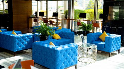 a group of blue chairs with yellow pillows in a lobby at Signature 1 Hotel Tecom in Dubai