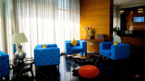 a living room with blue chairs and a table at Signature 1 Hotel Tecom in Dubai