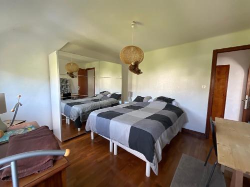 une chambre avec deux lits et un miroir dans l'établissement Il y a le ciel, le soleil, et la mer 4 chambres, à Bénodet