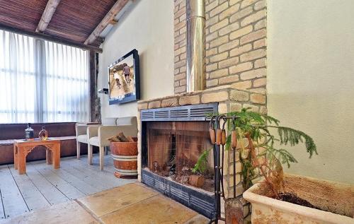 a living room with a brick fireplace with a plant at אחוזת יוסף-וילה מהממת למשפחות עם 2 בריכות וג'קוזי in Hatzor haglilit