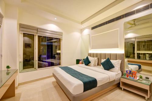 a bedroom with a large bed and two windows at Hotel Krishna - By RCG Hotels, Centrally Located, New Delhi in New Delhi