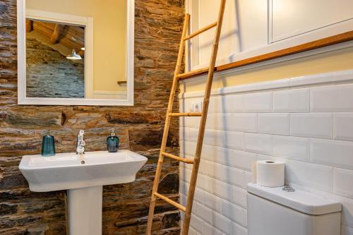 une salle de bains avec un lavabo et un miroir dans l'établissement Ático Casa Venancio, à Trabada