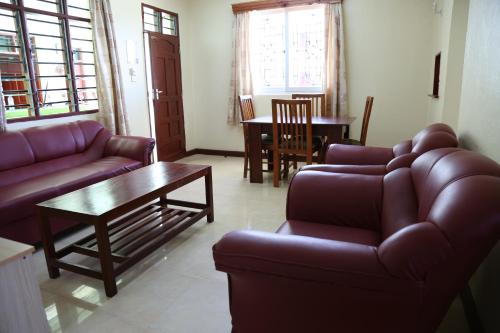 a living room with a couch and a table and chairs at Prestige Leisure Hotel in Mtwapa
