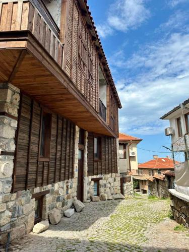 a wooden building with a balcony on the side of it at Sozopol Old Town - Apartment 4 in Sozopol