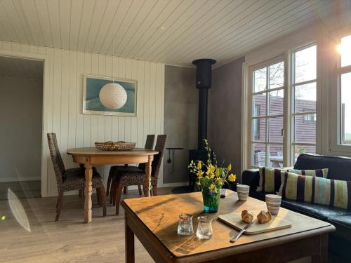 a living room with a table and a couch at One-of-a-kind waterfront wooden house in Hejls