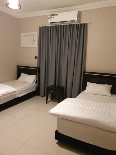 a hotel room with two beds and a window at ابراج الراحة بلازا شركة راحتي للشقق المخدومه in Taif