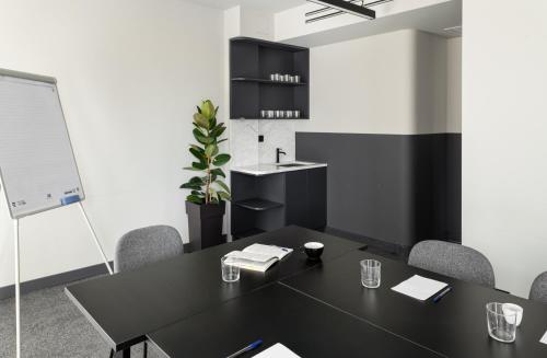 a meeting room with a black table and chairs at Zeus is Loose Hostel in Thessaloniki
