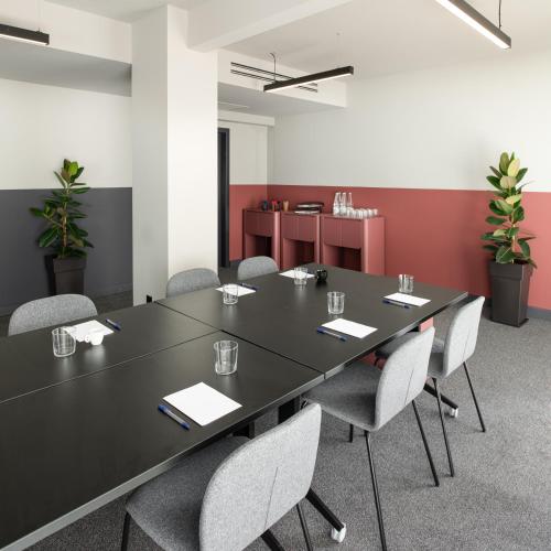 a conference room with a black table and chairs at Zeus is Loose Hostel in Thessaloniki