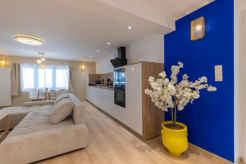 a living room with a couch and a blue wall at L'Andalouse - SPA Privatif - Jacuzzi Hammam Sauna in Mittelhausbergen