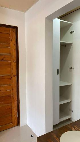 a room with white walls and a wooden door at RACHEL's INN in Dumaguete