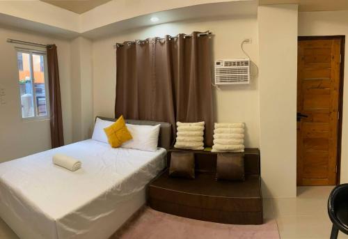 a small bedroom with a bed and a window at RACHEL's INN in Dumaguete