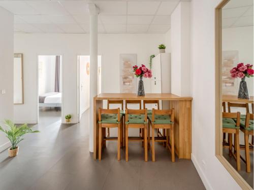 une salle à manger avec une table et des chaises en bois dans l'établissement Merveil - Family Suite - Marais - Turbigo I, à Paris