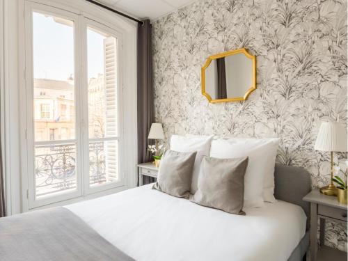 une chambre avec un lit blanc et un miroir dans l'établissement Merveil - Family Suite - Marais - Turbigo I, à Paris