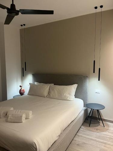 a bedroom with a large white bed with a table at Casa Francesca - Meravigliosa vista sul lago di Como in Menaggio