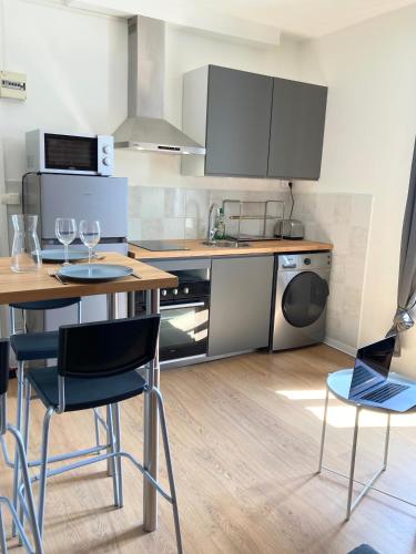 - une cuisine avec une table, 2 chaises et un ordinateur portable dans l'établissement T2 Home Sweet Home Gare Wifi Parking, à Évreux