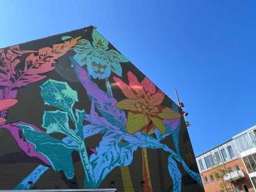 a mural on the side of a building with flowers at Central og rummelig lejlighed i Vejle in Vejle