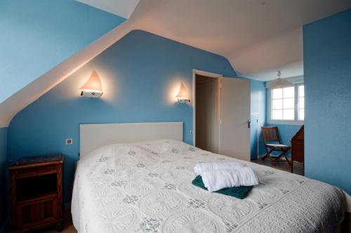 - une chambre avec un lit blanc aux murs bleus dans l'établissement La Pastourelle - 10min à pied de la plage, à Saint-Cast-le-Guildo