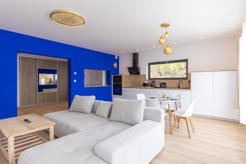 - un salon avec un canapé blanc et un mur bleu dans l'établissement La Palmeraie & SPA Privé - Jacuzzi Hammam Sauna, à Mittelhausbergen