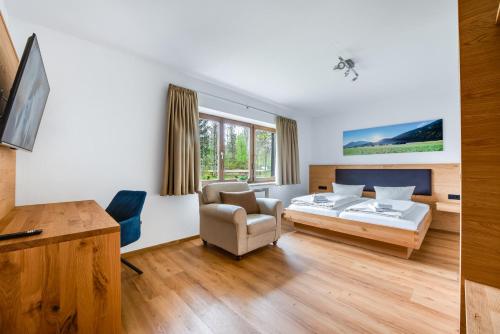a bedroom with a bed and a chair at Ferienhaus Am Brücklesbach in Grainau