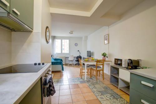 Il comprend une cuisine et une salle à manger avec une table. dans l'établissement Le Soleil Levant parking facile, à Toulouse