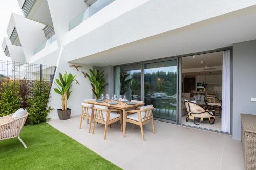 een eetkamer met een tafel en stoelen op een terras bij Luxury House Chaparral Golf E12 by AORA STAY in Mijas Costa
