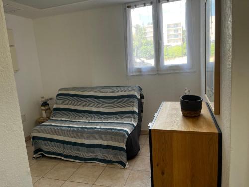a small bedroom with a bed and a window at PALMERAIE 220 in Sari Solenzara