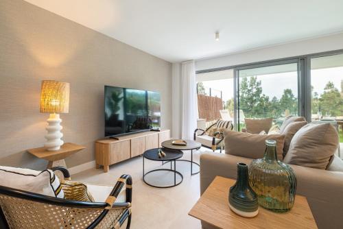 een woonkamer met een bank en een tv bij Luxury House Chaparral Golf E12 by AORA STAY in Mijas Costa