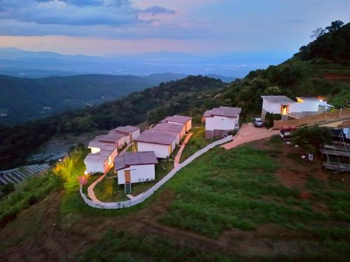 a group of houses on a hill at night at ไร่ดอยช้าง ม่อนเเจ่ม in Mon Jam