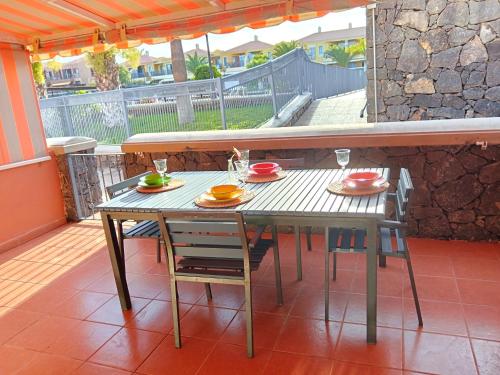 einen Tisch und Stühle auf einer Veranda mit einem Tisch und einem Chairsktop in der Unterkunft Atlantico breeze in Costa Del Silencio