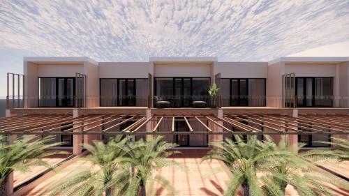 a building with palm trees in front of it at Hotel Al Mandar in Dakhla