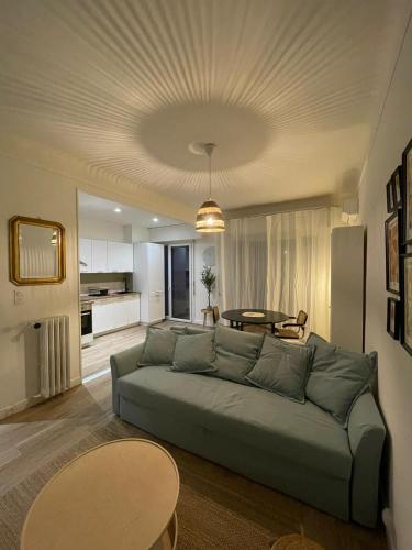 un salon avec un canapé vert et une table dans l'établissement Charmant T2 proche tramway et plages, à Nice