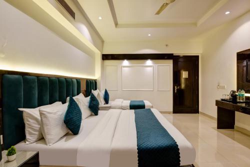 a bedroom with a large bed with blue and white pillows at Hotel Krishna - By RCG Hotels, Centrally Located, New Delhi in New Delhi