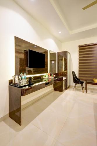 a living room with a television and a desk at Hotel Krishna - By RCG Hotels, Centrally Located, New Delhi in New Delhi