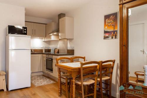 une cuisine avec une table, des chaises et un réfrigérateur dans l'établissement 1005-Charmant appartement à Pléneuf-Val-André, à deux pas des plages !, à Pléneuf-Val-André